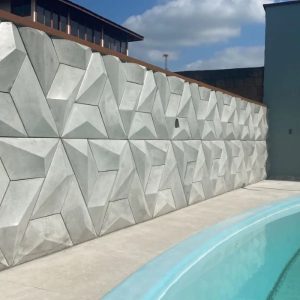 O revestimento 3D externo pode ser usado em muros,fachadas e garagens. Imagem de  uma parede revestida com cimento.